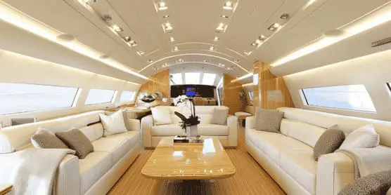 Luxury private jet interior with cream sofas and plush cushions
