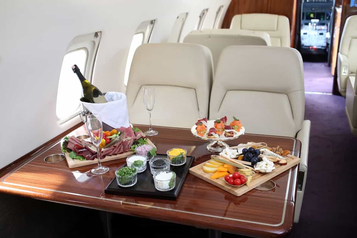 Luxury catering spread on a private jet charter, showcasing gourmet food in a premium cabin